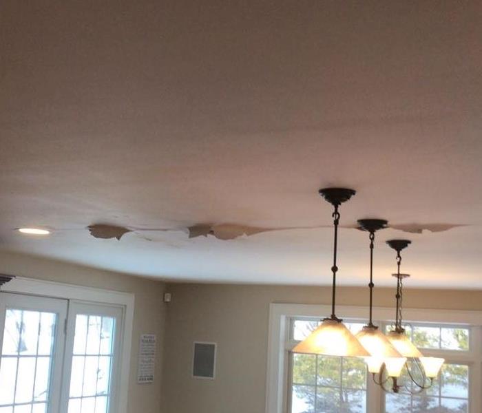 Photo of paint peeling from ceiling as a result of water damage